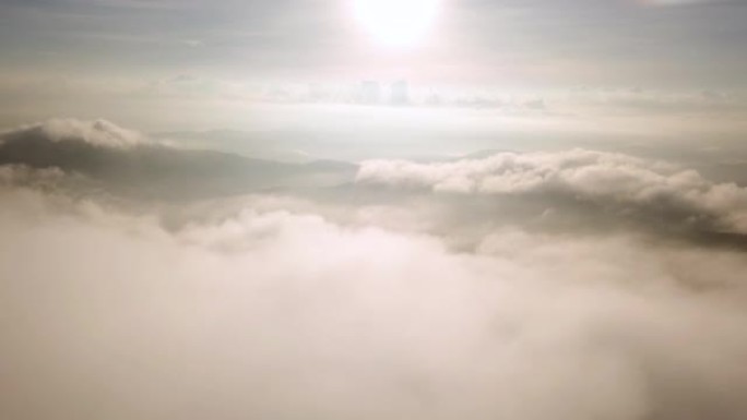 空中拍摄到云层和天空上方的空中，日出在山上