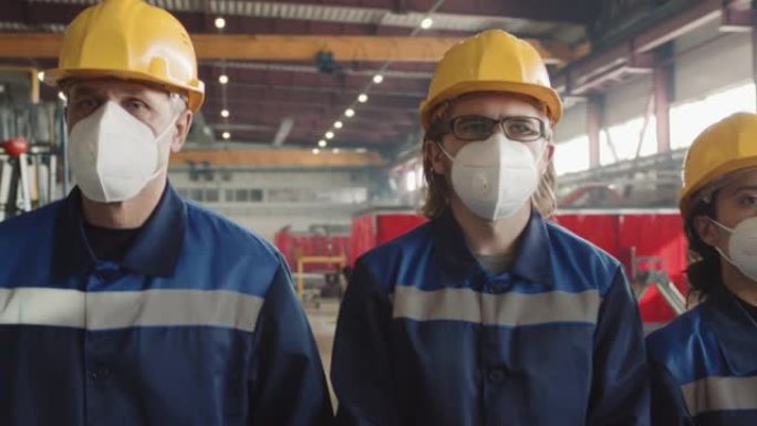 戴着呼吸面罩的工人穿过工厂