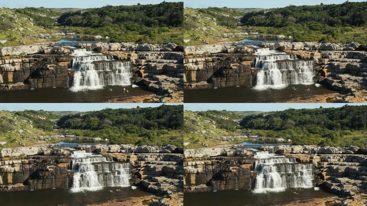 南非东开普省姆坎巴蒂自然保护区，一对夫妇在壮丽的马蹄瀑布中游泳的鸟瞰图
