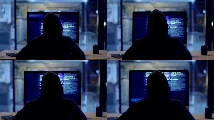 黑客或网络犯罪分子晚上坐在电脑上在线窃取信息。蒙面神秘人编码间谍软件、恶意软件和病毒，以实施欺诈、盗