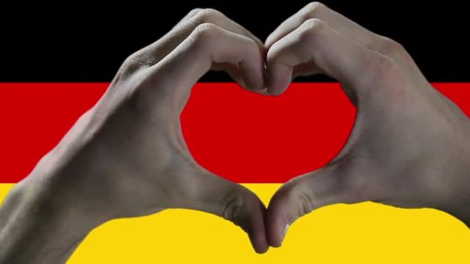 男人的手在德国国旗上做心脏标志。特写。