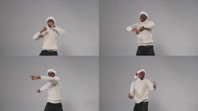 一个戴着圣诞帽和羊毛针织毛衣的黑皮肤男人在灰色背景上跳舞