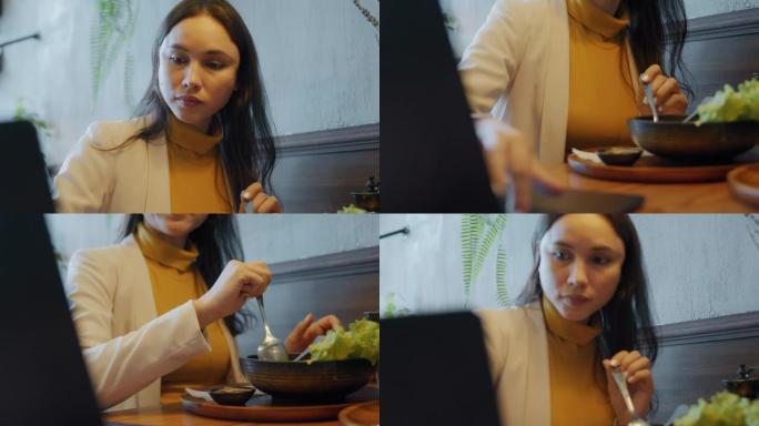 亚洲女商人在餐馆工作期间吃饭。
