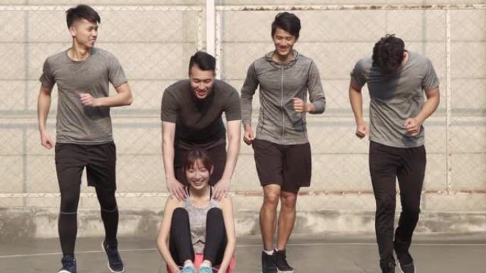 五名亚洲年轻人在室外篮球场上玩得开心