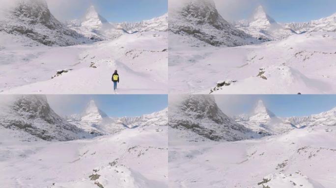 旅行者在瑞士马特宏峰山顶行走的年轻女性的空中无人机视图。大自然中的幸福。具有多样性概念的体验式旅行。