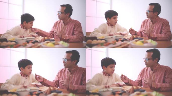 父子一起吃饭餐桌上摆满了印度食物美食
