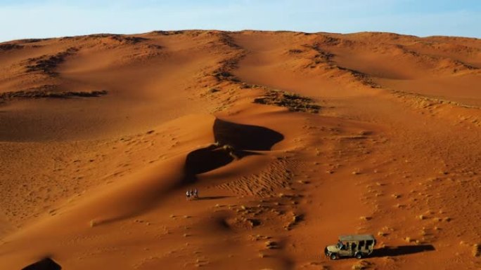 游客的鸟瞰图走进沙丘，欣赏风景秀丽的纳米比亚纳米布沙漠的壮观景观