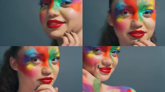 工作室背景上的面部、女人和彩虹画化妆、创意艺术和幻想化妆品。肖像女孩，色彩和创造力的飞溅，面部设计和