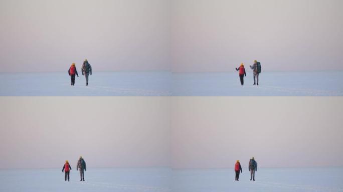 背着背包的男人和女人在雪域中穿行。慢动作