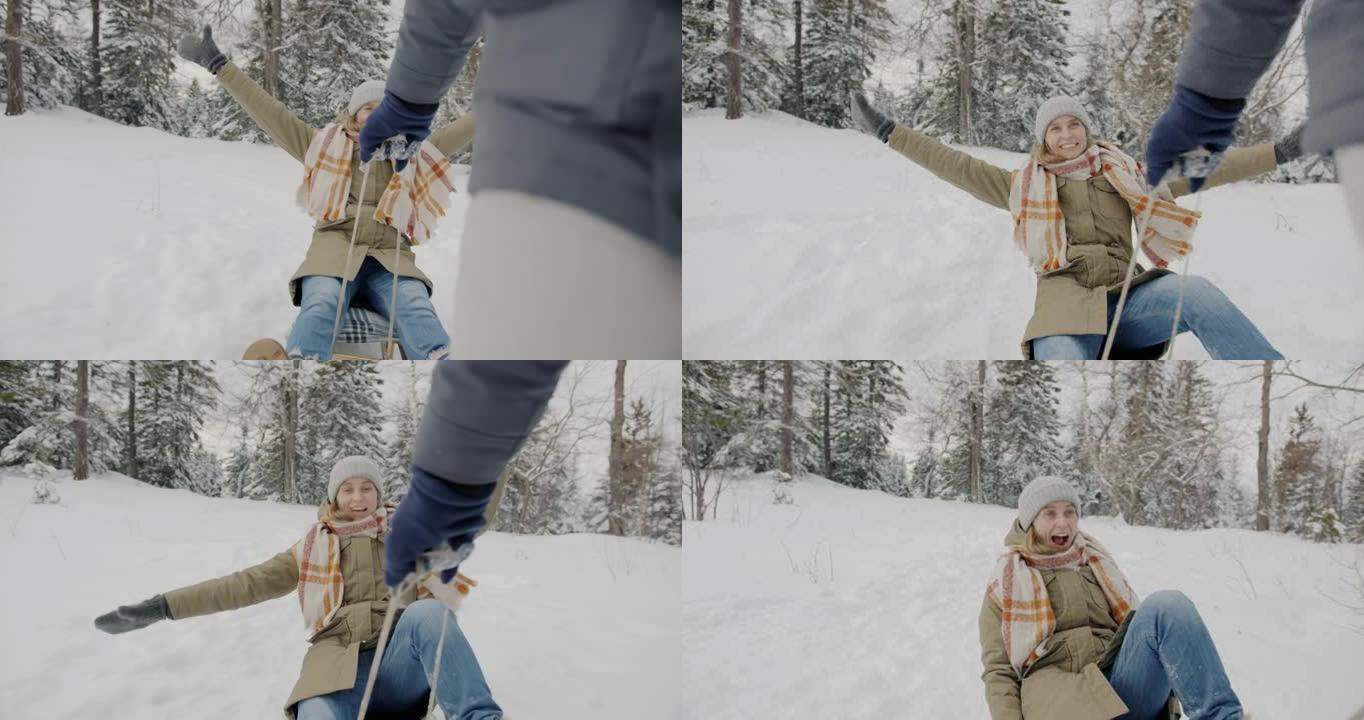 快乐的女士在冬天的森林里拉着雪橇享受骑行的肖像