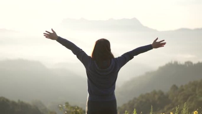 女旅行者徒步上山庆祝成功