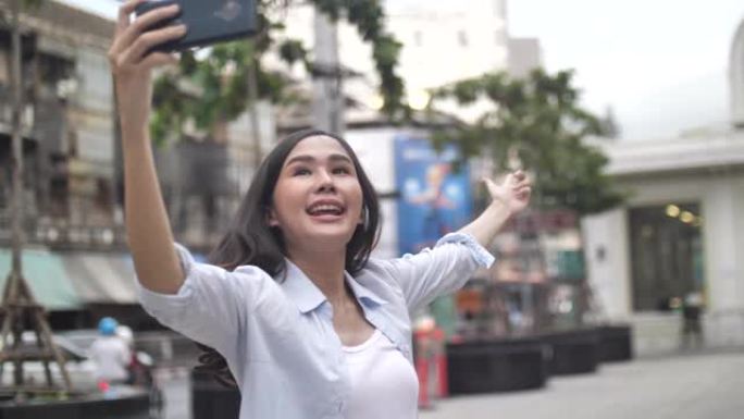 女性旅行博客在旅行网络博客中使用智能手机摄像头在步行期间发布