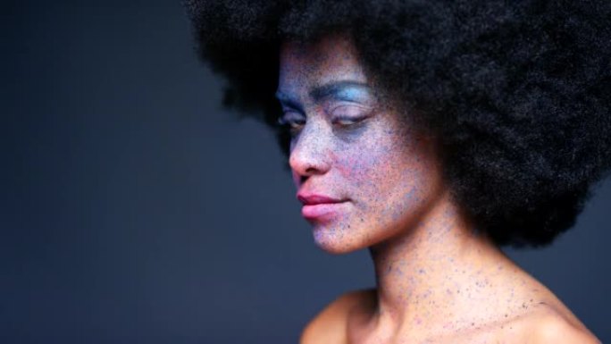 深色工作室背景上的彩色面部彩妆，黑人女性肖像和独特的创意艺术和幻想化妆品。非洲人体艺术家，皮肤上大胆