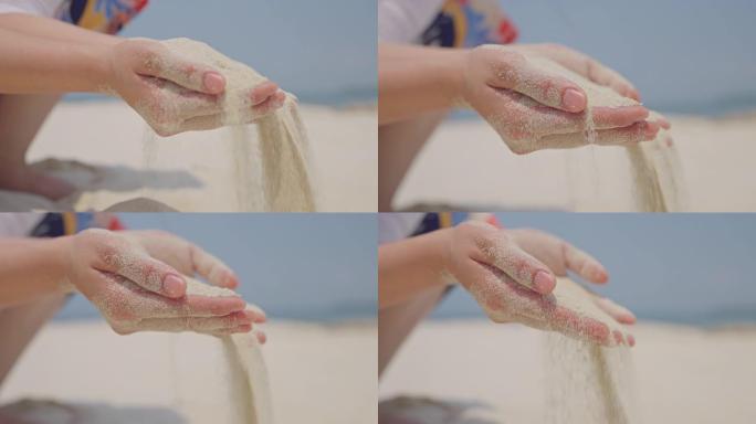 在凉爽的夏日微风中，无法辨认的女人的手穿过异国情调的海滩