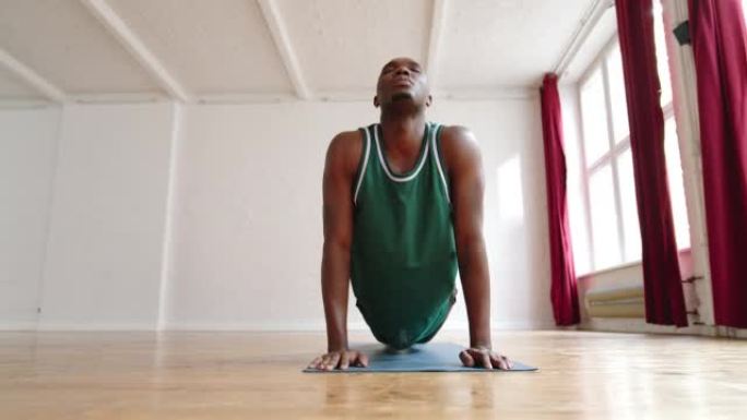 非洲男子在瑜伽课上进行伸展运动