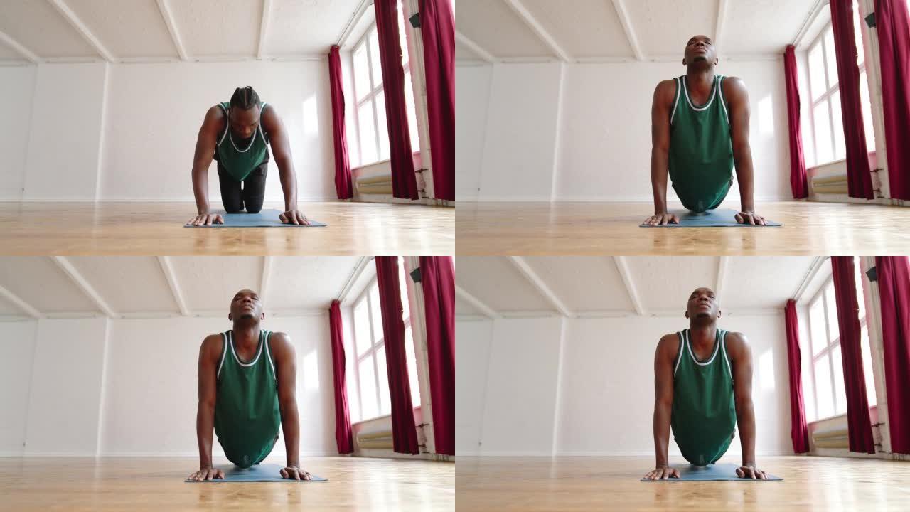 非洲男子在瑜伽课上进行伸展运动