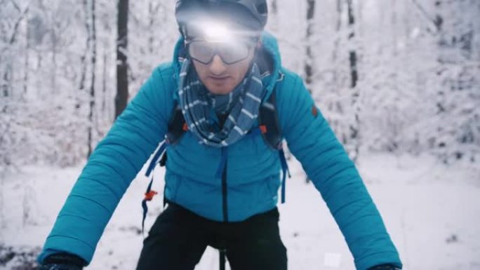 成年男子骑电动自行车冬季在一片白雪皑皑的森林