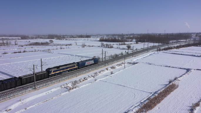 雪后行驶在乡村田野货运火车