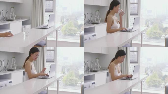 年轻的商务女士早上使用笔记本电脑在线浏览