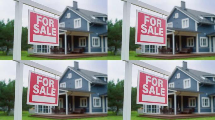 关闭一个红色的房地产出售在风中扑朔迷离。背景与一个大的蓝色时尚的乡村房子。郊区住宅出售的住房市场概念