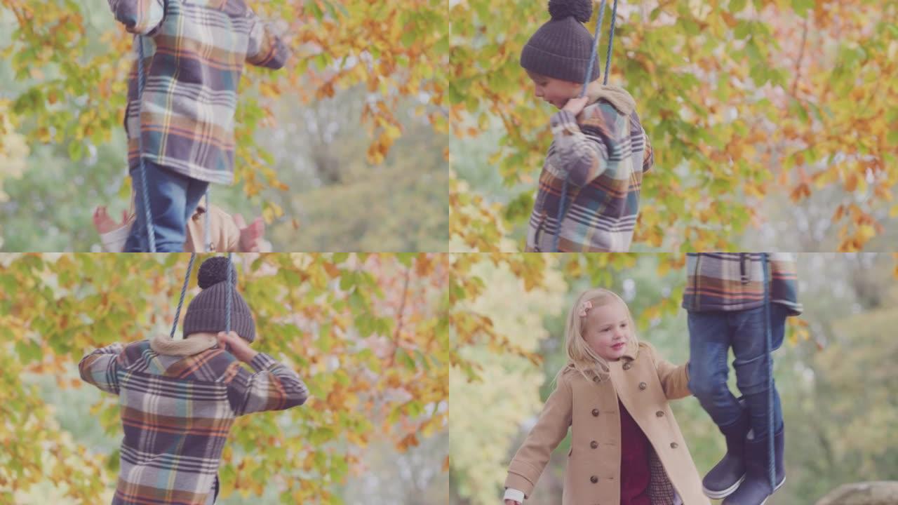 兄弟姐妹在秋季花园的绳索秋千上玩耍的特写镜头