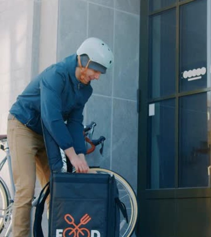 快乐的送餐男子在自行车上穿着保暖背包向一位美丽的女性顾客提供餐厅订单。快递员送外卖午餐。垂直屏幕方向