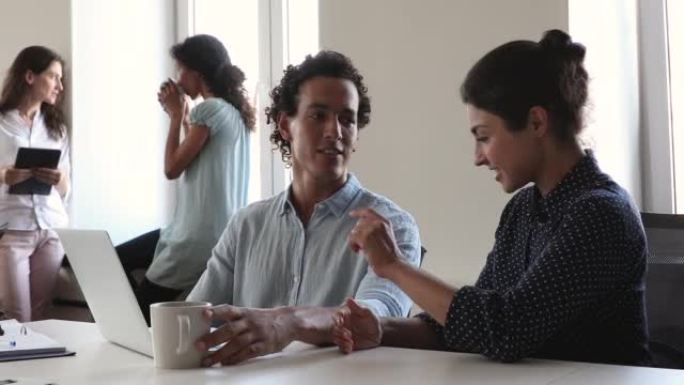 西班牙裔男性导师向年轻的印度女士新手解释工作