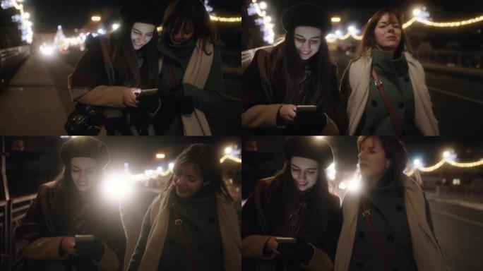 两名年轻女子在街上行走时使用手机