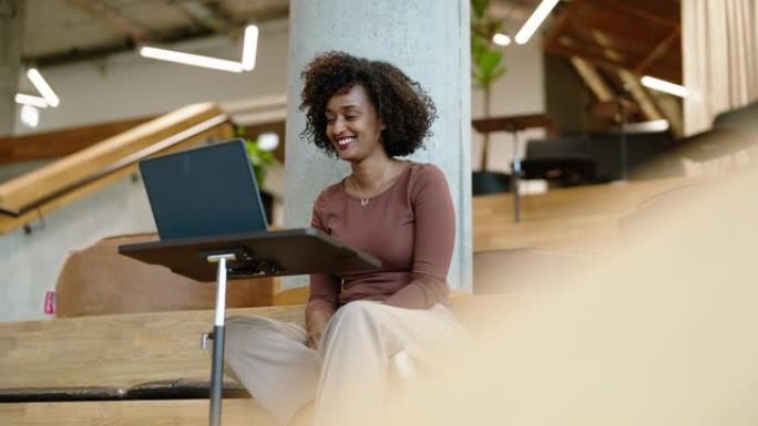 创意办公室的快乐女商人用笔记本电脑视频通话