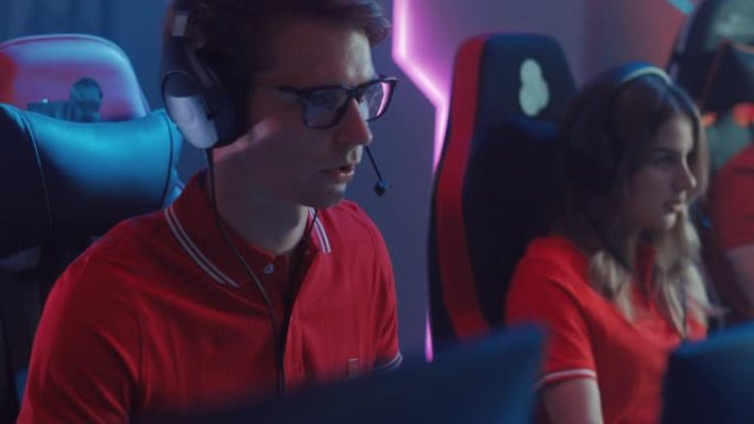 专业玩家玩电脑视频游戏，与队友在锦标赛上与头戴式耳机交谈。职业玩家的Esport团队玩电脑游戏。时尚