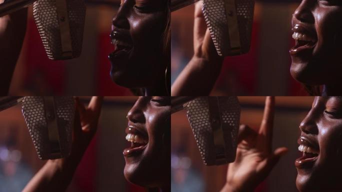 非裔美国女艺术家在音乐工作室的麦克风上唱歌