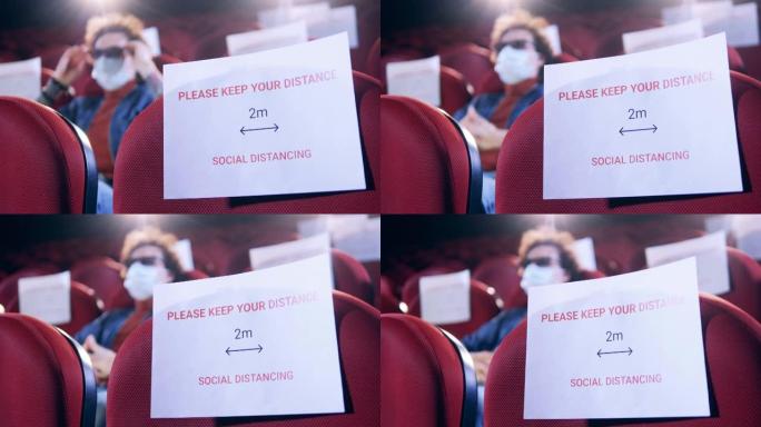 电影院大厅里有一个男人，座位上有社交距离的迹象
