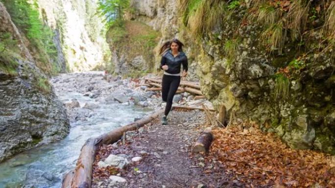 活跃的女人在山溪山谷慢跑