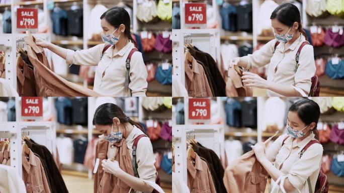 新常态购物，亚洲女性在服装店用口罩购物