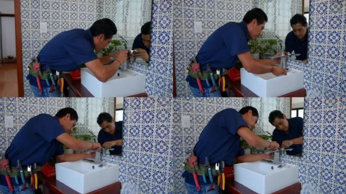 拉丁美洲水管工在顾客家中固定浴室的水槽水龙头