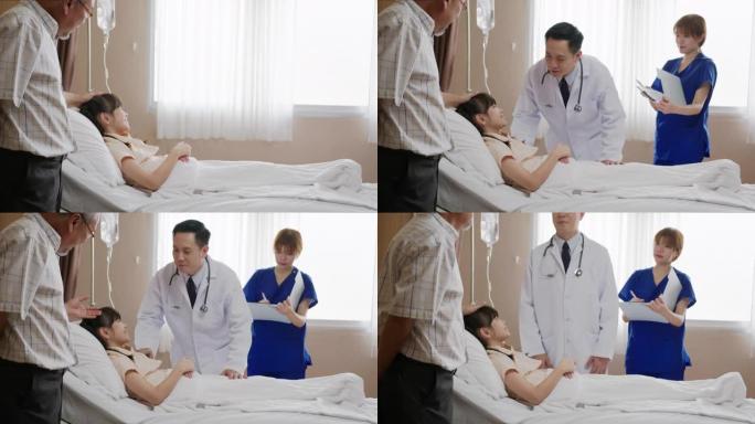 亚洲友好的医生男子与父母和可爱的小孩病人躺在病床上，检查健康。儿童医院儿科病房。医生随访病情患者。