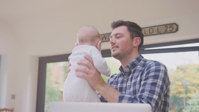 工作的父亲在家里使用笔记本电脑，同时与微笑的宝贝儿子在空中举起他