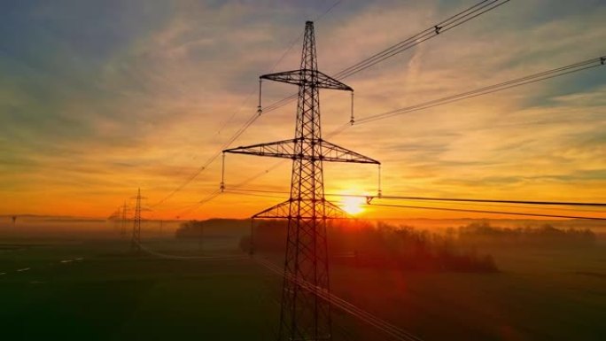 日落时乡村上空的电塔和电线