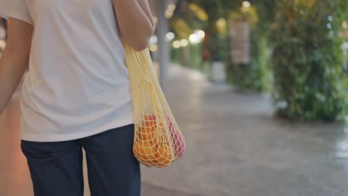 潮人亚洲妇女在农贸市场里拿着可重复使用的购物袋