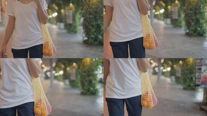 潮人亚洲妇女在农贸市场里拿着可重复使用的购物袋