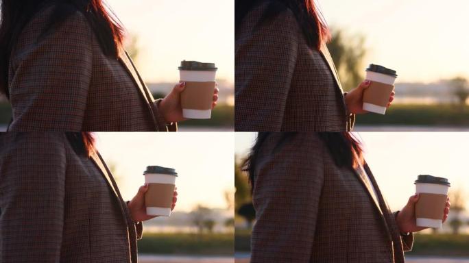 女子手持纸咖啡杯晨间散步