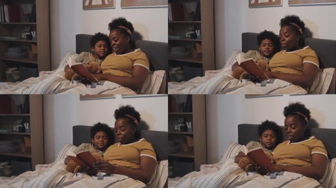 阿姨在床上给男孩看书