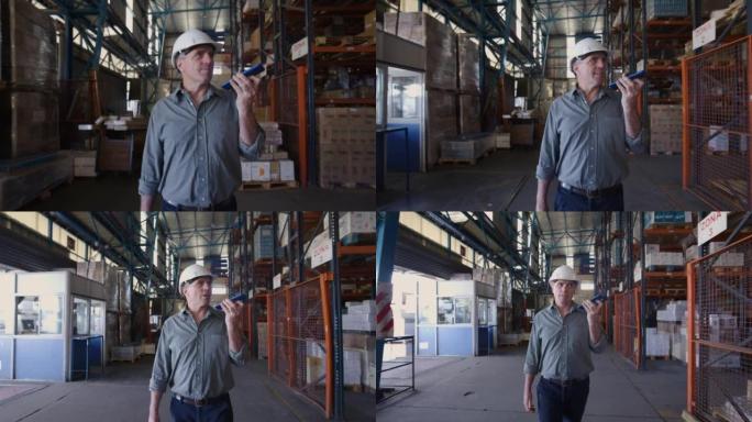 拉丁美洲主管在配送仓库工作，边走边用扬声器电话交谈