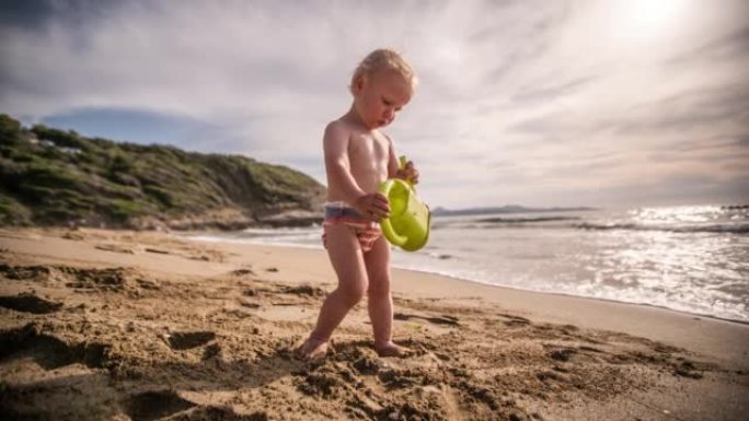 小男孩带着玩具在沙滩上玩耍
