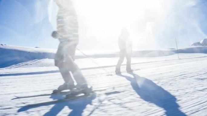 滑雪者在一个完美的阳光明媚的冬日里骑着田园诗般的山地滑雪胜地滑雪道