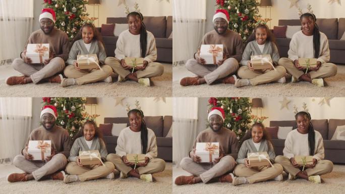带有圣诞节礼物的快乐非裔美国人家庭肖像