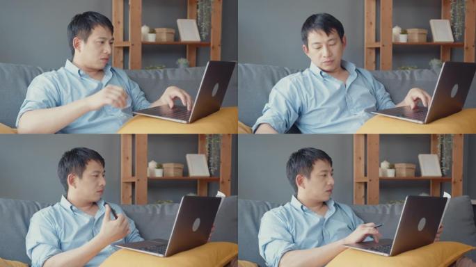 自由职业者亚洲男休闲服使用笔记本电脑在线学习在家里的客厅。