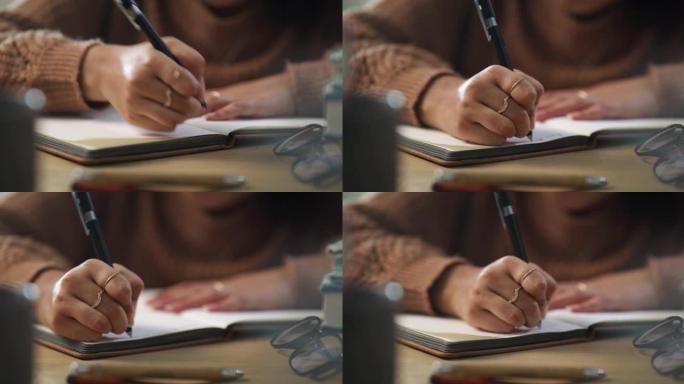 4k视频片段，一个无法识别的女人独自坐在家里，在学习时在书中写笔记