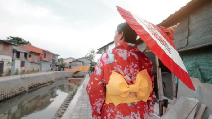 浴衣中的年轻女子在人行道上独自旅行