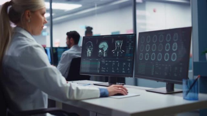 医学医院研究实验室: 女性医学科学家使用计算机进行脑部扫描MRI图像，找到治愈方法。专业神经科医生分